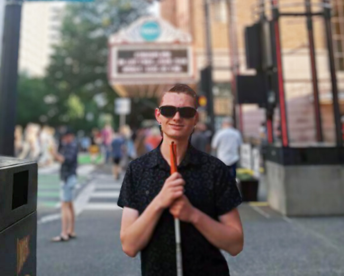 地球Gen青年研究员查尔斯·约翰逊在繁忙的人行道上摆姿势拍照.